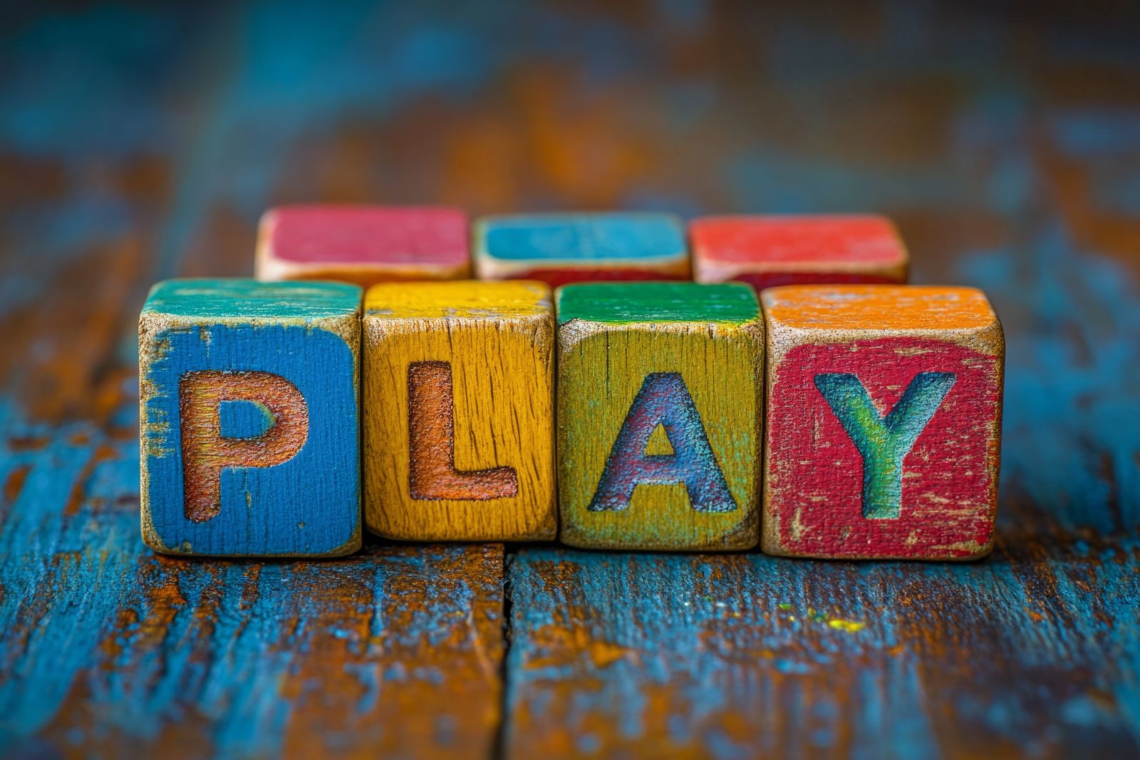 Bunte Holzwürfel mit dem Wort PLAY — Lernen beginnt mit Neugier